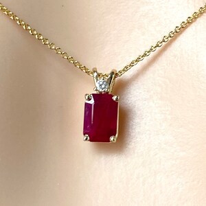 Puede incluir: Un collar de cadena de oro con un colgante que presenta una piedra preciosa de rubí rectangular roja y un pequeño acento de diamante.