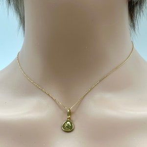May include: A gold chain necklace with a small gold pendant featuring an angel design.
