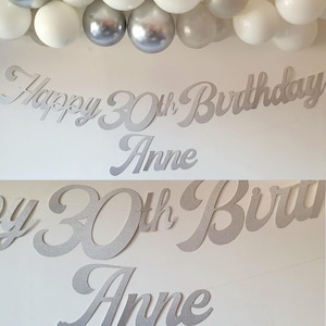 May include: Silver glitter Happy 30th Birthday banner with the name Anne. The banner is made of cardboard and is perfect for a birthday party.