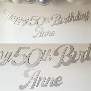 May include: Silver glitter Happy 50th Birthday banner with the name Anne. The banner is made of cardstock and is perfect for a 50th birthday party.