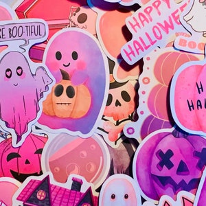 May include: A collection of Halloween themed stickers featuring ghosts, pumpkins, and the phrase "Happy Halloween". The stickers are in various shades of pink, purple, and orange.