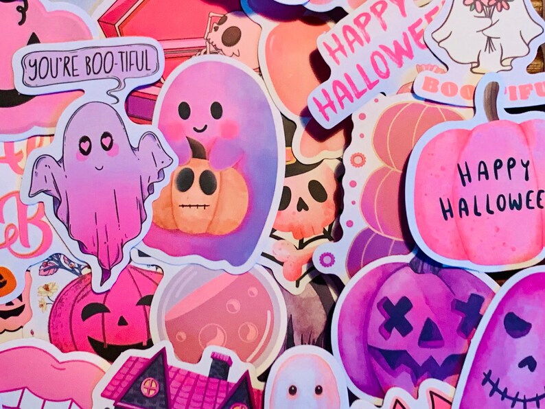 May include: A collection of Halloween themed stickers featuring ghosts, pumpkins, and the phrase "Happy Halloween". The stickers are in various shades of pink, purple, and orange.