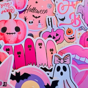 May include: A collection of pink and white Halloween stickers featuring ghosts, pumpkins, bats, and the words "Happy " and "Halloween".
