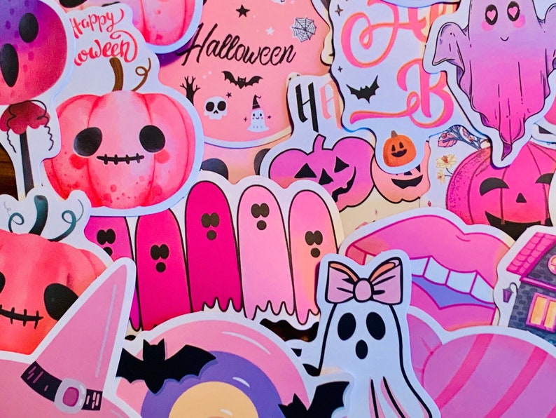 May include: A collection of pink and white Halloween stickers featuring ghosts, pumpkins, bats, and the words "Happy " and "Halloween".