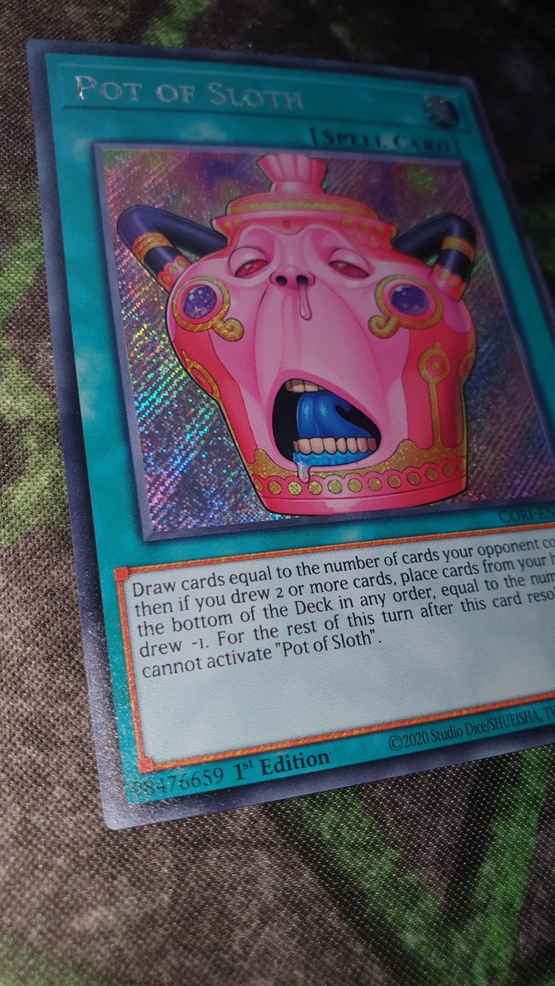 May include: A holographic trading card titled Pot of Sloth, a spell card with a teal border. The central illustration features a pink, anthropomorphic pot with a wide-open mouth, blue tongue, and dark horns, set against a shimmering, rainbow-colored background.