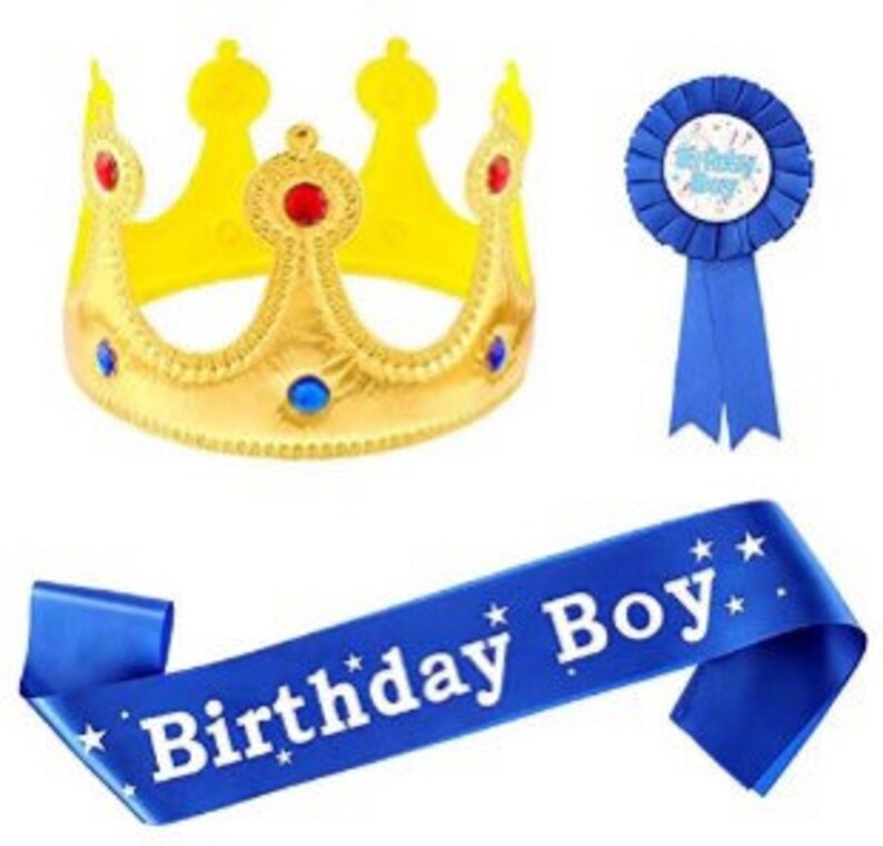 Puede incluir: Un conjunto de fiesta de cumplea&ntilde;os azul y dorado con una corona, una banda y una cinta azul con una estrella blanca y las palabras "Feliz cumplea&ntilde;os" en ella.