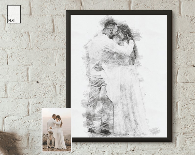 May include: A black and white pencil sketch of a couple embracing. The man is wearing a white shirt and the woman is wearing a white dress. The sketch is framed in a black frame.