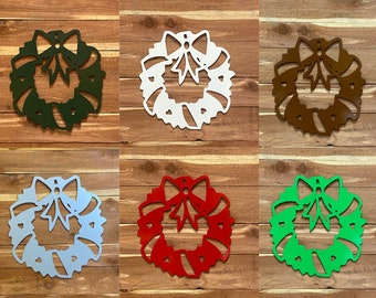 May include: Six metal Christmas wreaths in different colors. The wreaths are decorated with candy canes and a bow. The colors are green, white, brown, light blue, red, and green.