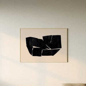 K&ouml;nnte beinhalten: Ein beiges, L-f&ouml;rmiges Sofa mit einem schwarz-wei&szlig;en abstrakten Kunstbild an der Wand dahinter. Das Sofa steht in einem Wohnzimmer mit einem wei&szlig;en Couchtisch und einem geflochtenen Korb.
