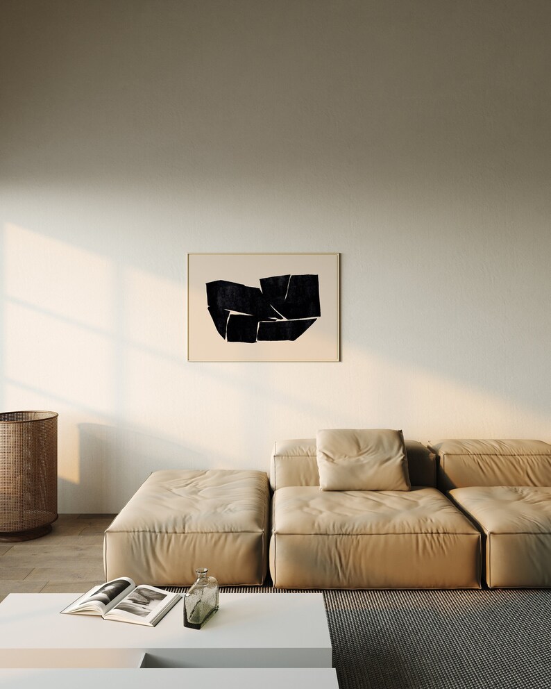 K&ouml;nnte beinhalten: Ein beiges, L-f&ouml;rmiges Sofa mit einem schwarz-wei&szlig;en abstrakten Kunstbild an der Wand dahinter. Das Sofa steht in einem Wohnzimmer mit einem wei&szlig;en Couchtisch und einem geflochtenen Korb.