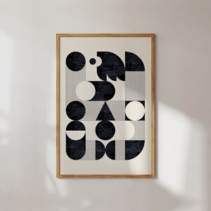 Puede incluir: Una impresi&oacute;n de arte abstracto geom&eacute;trico en blanco y negro con c&iacute;rculos, semic&iacute;rculos y un tri&aacute;ngulo. La impresi&oacute;n est&aacute; enmarcada en un marco de madera natural.