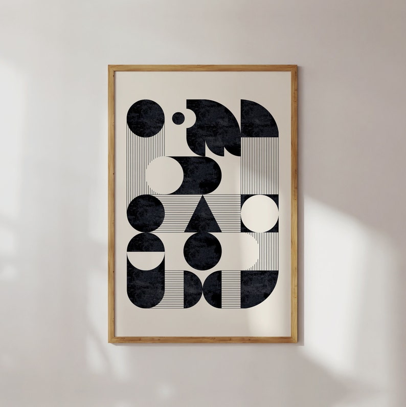 Puede incluir: Una impresi&oacute;n de arte abstracto geom&eacute;trico en blanco y negro con c&iacute;rculos, semic&iacute;rculos y un tri&aacute;ngulo. La impresi&oacute;n est&aacute; enmarcada en un marco de madera natural.