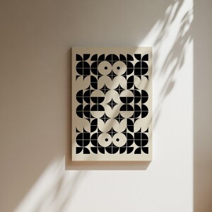 May include: A black and white geometric pattern print on a cream background. The pattern is made up of circles, half circles, and squares.