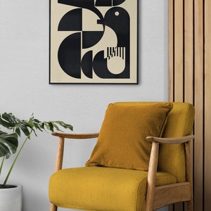 May include: A black and white geometric abstract art print in a black frame hanging on a white wall above a mustard yellow armchair with a wooden frame.