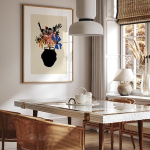 Pu&ograve; includere: Un tavolo da pranzo bianco con un piano a motivi bianchi e dorati, quattro sedie con sedute in vimini intrecciato e una lampada a sospensione in ceramica bianca sopra il tavolo. Una stampa incorniciata di un vaso di fiori &egrave; appesa al muro dietro il tavolo.