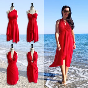Puede incluir: Un vestido rojo de tirantes con un detalle de nudo en el pecho y un dobladillo alto-bajo. El vestido se muestra en un maniquí y una modelo lo lleva puesto en una playa.