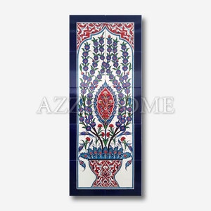 Pode incluir: Um azulejo de cer&acirc;mica branco com uma borda azul e um desenho floral em tons de azul, vermelho e verde. O desenho apresenta um vaso com um arranjo floral estilizado.