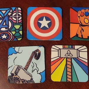 May include: Set of six square coasters featuring colorful stained glass designs of various Marvel characters. The coasters feature Captain America's shield, Thor's hammer, Iron Man's arc reactor, the Infinity Gauntlet, and the Avengers logo.