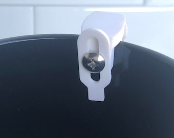 May include: White plastic hook with a screw, attached to the inside of a black ceramic mug.