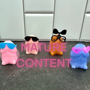 May include: Four small, colorful, cartoon-like figures with different styles of sunglasses. The figures are made of a soft, rubbery material and have a dotted texture. The figures are arranged in a row on a gray surface.