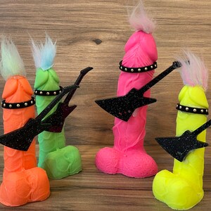 May include: Four colourful figurines with black glitter guitars. Each figurine has a different colour and a black studded belt around the waist.