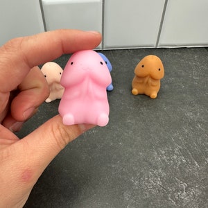 Puede incluir: Una colecci&oacute;n de figuras novedosas con forma de pene, de colores brillantes. Las figuras son de varios tonos, incluyendo rosa, beige, azul y melocot&oacute;n. Cada figura tiene una cabeza peque&ntilde;a y redondeada y una cara sonriente. Las figuras est&aacute;n hechas de un material suave y flexible.