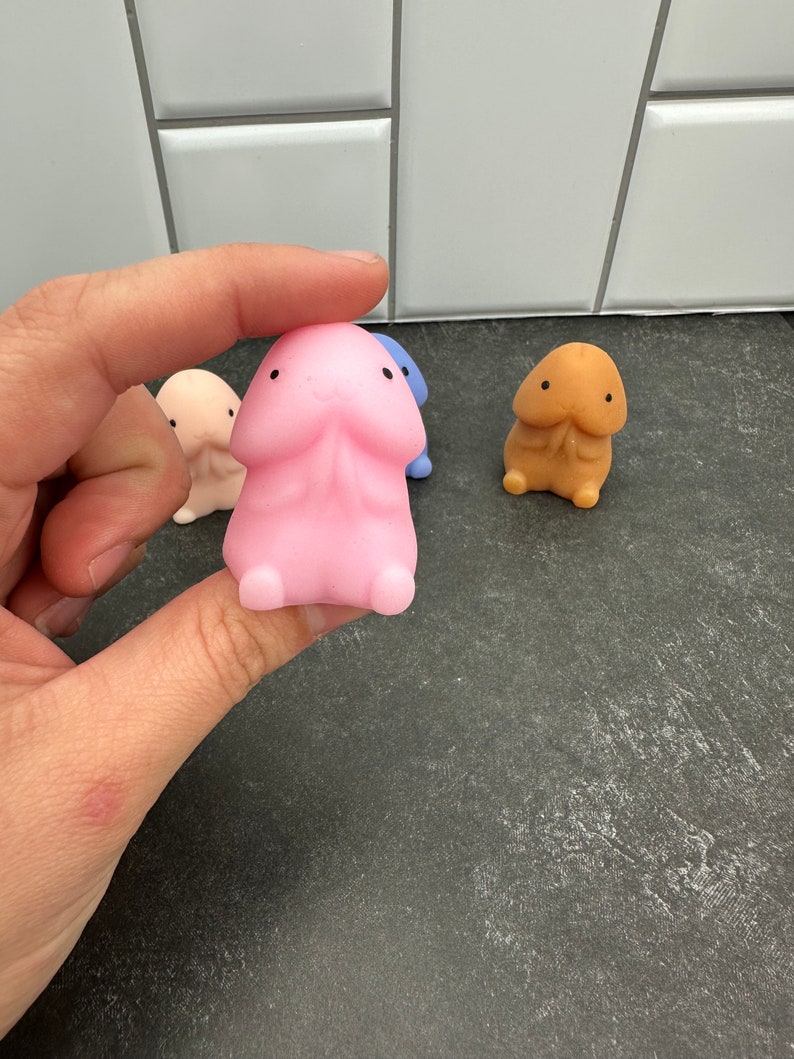 Puede incluir: Una colecci&oacute;n de figuras novedosas con forma de pene, de colores brillantes. Las figuras son de varios tonos, incluyendo rosa, beige, azul y melocot&oacute;n. Cada figura tiene una cabeza peque&ntilde;a y redondeada y una cara sonriente. Las figuras est&aacute;n hechas de un material suave y flexible.