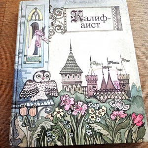 May include: Vintage children's book with a colorful illustration of a castle, flowers, and an owl. The book cover features the title in a stylized font and a whimsical design, evoking a fairy tale theme.