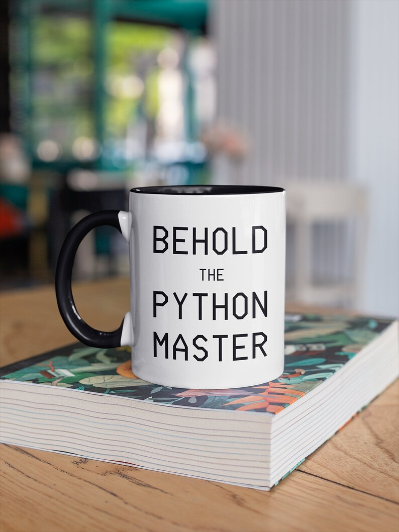 Puede incluir: Taza de cer&aacute;mica blanca con asa negra y borde negro. La taza tiene el texto "Behold the Python Master" impreso en negro.