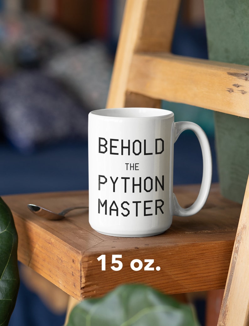 Puede incluir: Taza de cer&aacute;mica blanca con texto negro que dice "Behold the Python Master". La taza es de 15 onzas y est&aacute; sobre una superficie de madera.