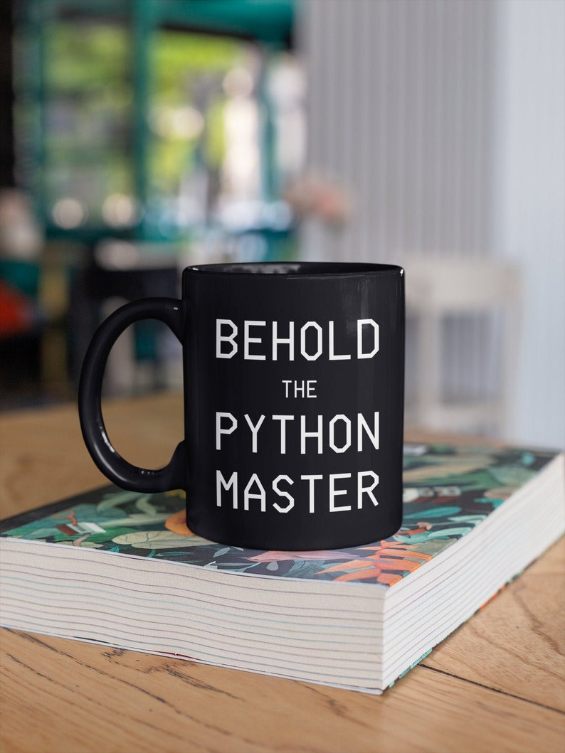 Puede incluir: Taza de caf&eacute; de cer&aacute;mica negra con texto blanco que dice "Behold the Python Master".