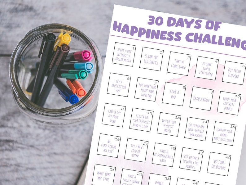 May include: A printable 30-day happiness challenge checklist with a pink watercolor background. The checklist includes activities such as taking a long walk, reading a book, and trying a new food.