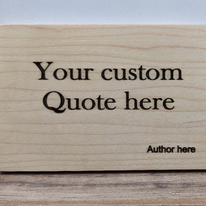 May include: A wooden sign with the text "Your custom Quote here" and "Author here" engraved on it.