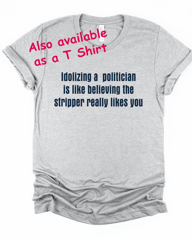 Pode incluir: T-shirt cinza claro com o texto "Idolizing a politician is like believing the stripper really likes you" em azul escuro. O texto "Also available as a T Shirt" &eacute; rosa.