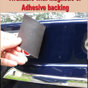Pode incluir: Um &iacute;m&atilde; retangular preto &eacute; mostrado contra um carro azul escuro. O texto "Available with Magnetic or Adhesive backing" &eacute; exibido em vermelho na parte superior da imagem.