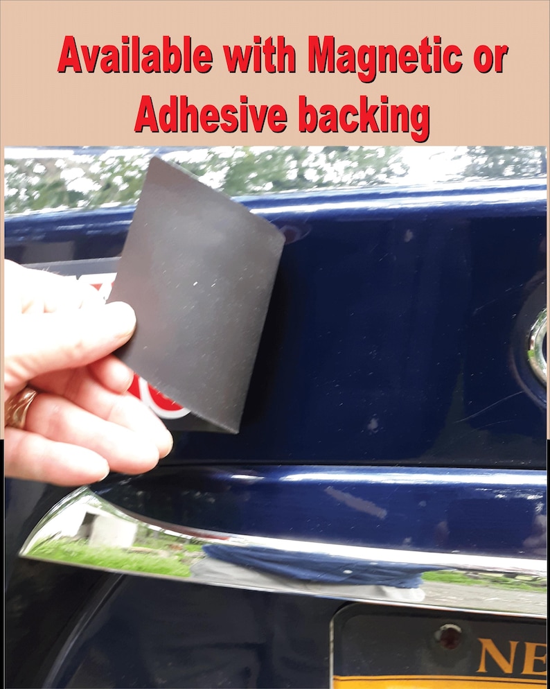 Pode incluir: Um &iacute;m&atilde; retangular preto &eacute; mostrado contra um carro azul escuro. O texto "Available with Magnetic or Adhesive backing" &eacute; exibido em vermelho na parte superior da imagem.
