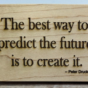 May include: Wooden sign with the quote "The best way to predict the future is to create it." attributed to Peter Drucker.
