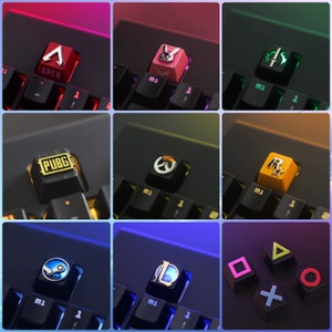 May include: A keyboard with keycaps featuring various game logos, including Apex, PUBG, Overwatch, and more. The keycaps are made of metal and have a glossy finish.