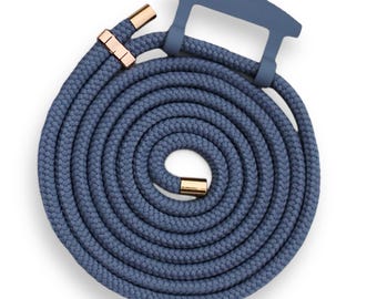 Op de afbeelding: Een opgerolde, blauwe telefoonriem van touw met goudkleurige metalen accenten. De riem heeft een bijpassende blauwe handgreep aan de bovenkant. Het touw is dik en lijkt gemaakt van een geweven materiaal.