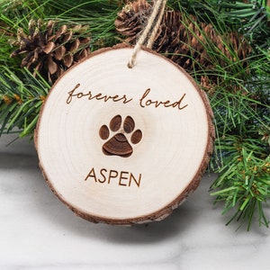 May include: A wooden ornament with the text "forever loved" and a paw print. The name "ASPEN" is written below the paw print.