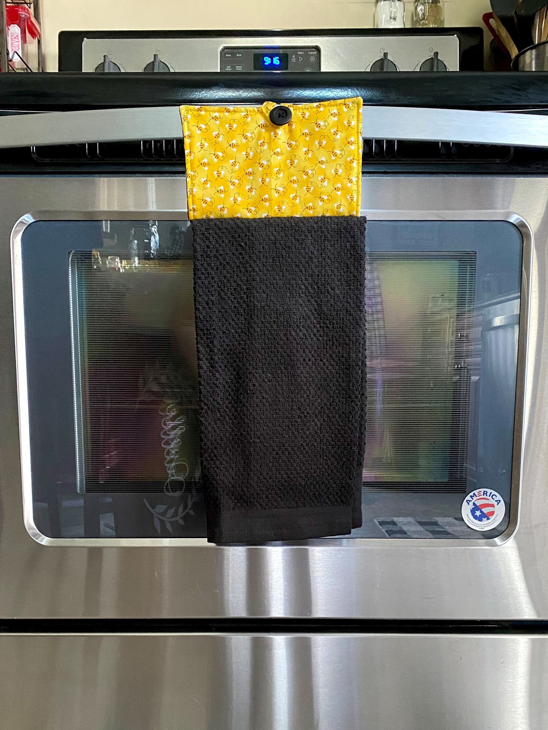 Tea towel or drying cloth hanging on an oven door handle of a