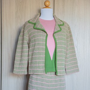 May include: A pink and green striped knit jacket and skirt set. The jacket has a green trim and the skirt is knee-length.