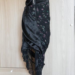 Peut inclure: Jupe noire avec un motif floral et un rev&ecirc;tement en satin. La jupe est dot&eacute;e d'une fermeture &eacute;clair et d'un design superpos&eacute; avec une bordure en dentelle. L'imprim&eacute; floral comprend des accents roses et verts.