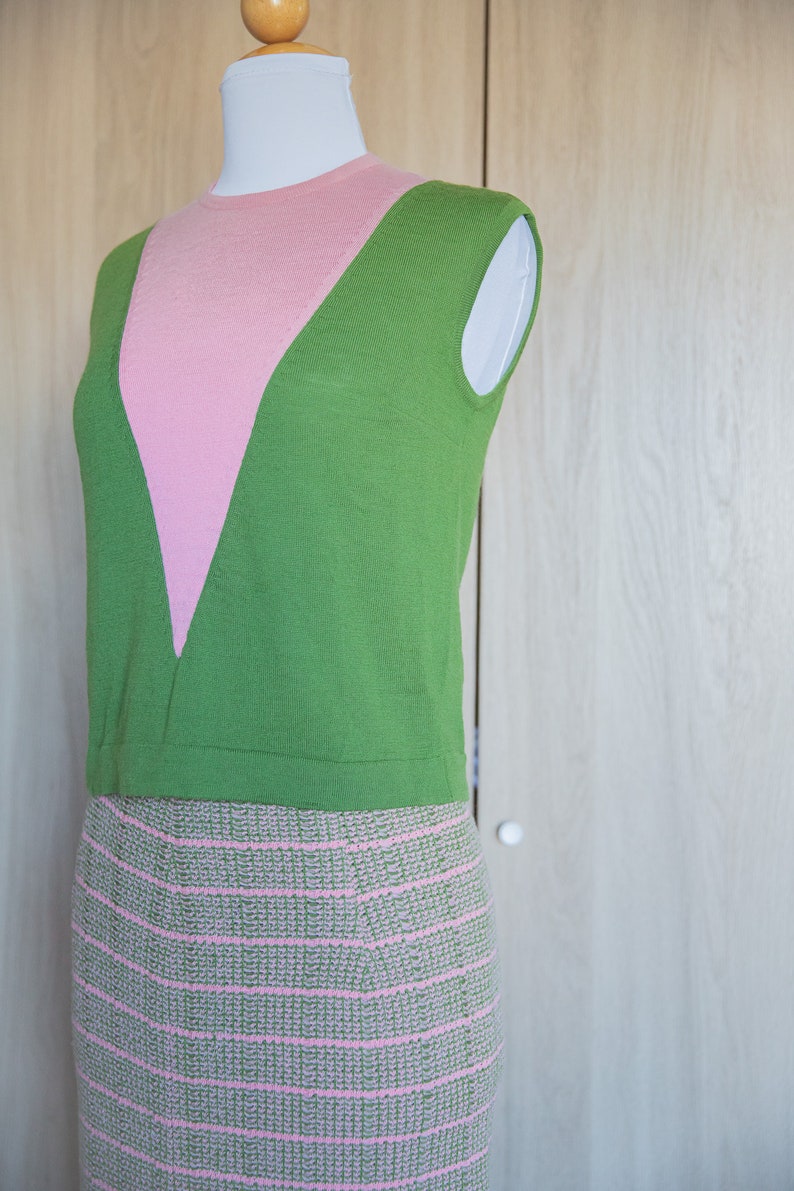 May include: A sleeveless green and pink knit top with a pink and green striped skirt.