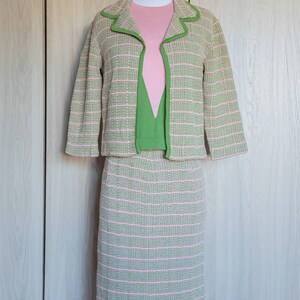 May include: A green and pink striped knit jacket and skirt set. The jacket has a green trim and the skirt is knee-length.