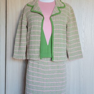 May include: A pink and green striped knit suit with a matching skirt and jacket. The jacket has a green trim around the collar and cuffs.