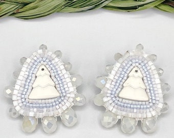 Pendientes de árboles nevados con cuentas de métis