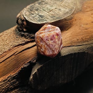 Puede incluir: Una taza de cerámica blanca con un asa negra y el texto "But First, Coffee" en negrita negra. La taza se encuentra sobre un fondo borroso, sugiriendo un ambiente acogedor.