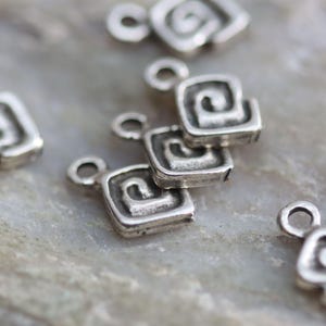 Puede incluir: Pendientes de plata con un dise&ntilde;o en espiral. Cada pendiente tiene un peque&ntilde;o bucle para sujetarlo a un collar o pulsera.