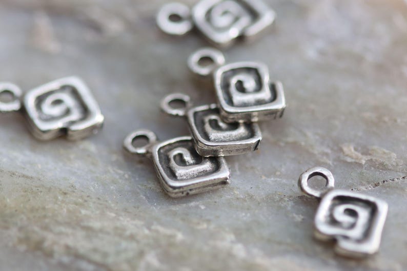 Puede incluir: Pendientes de plata con un dise&ntilde;o en espiral. Cada pendiente tiene un peque&ntilde;o bucle para sujetarlo a un collar o pulsera.